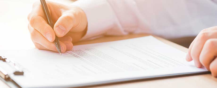 Como contratar seguro garantia? Na imagem, pessoa lendo contrato após enviar a documentação necessária para a análise da seguradora que oferece o seguro caução