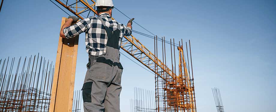 Como contratar seguro garantia executante construtor? Na imagem, home trabalhando em construção após cotar e contratar seguro online