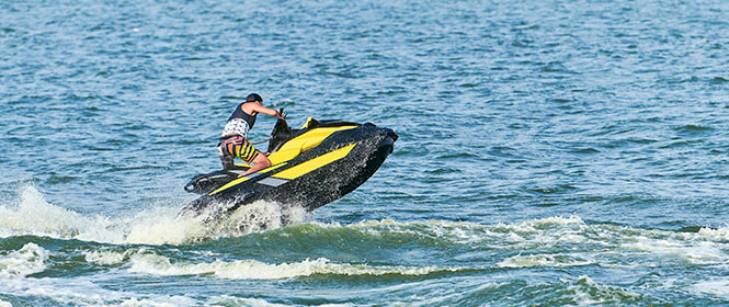 Qual seguradora faz seguro náutico? Na imagem, homem andando de jet ski após fazer simulação de seguro e contratá-lo