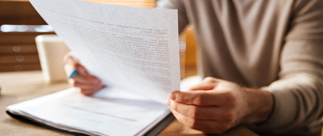 Qual a diferença entre cobertura compreensiva e exclusiva? Na imagem, pessoa jurídica com contrato de seguro com cobertura compreensiva em mãos