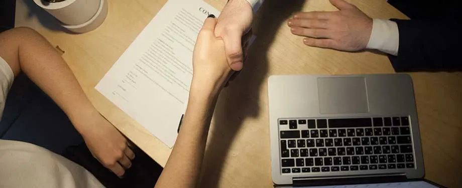 Como funciona o Retention Bond? Na imagem, pessoas apertam a mão em representação a firmação de acordo, que pode ser protegido por seguro garantia de retenção de pagamento