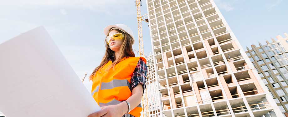 Como funciona o seguro garantia executante construtor? Na imagem, mulher trabalhando em construção, que tem garantia de cumprimento por meio de seguro