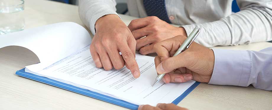 Como funciona a apólice de seguro garantia? Na imagem, corretor explicando a cliente que a apólice funciona como uma garantia de obrigações contratuais