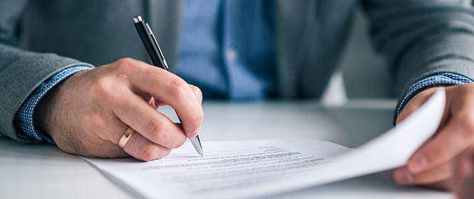 Quanto custa um seguro garantia licitante? Na imagem, dono de empresa aprovado em processo de licitação assinando contrato de seguro