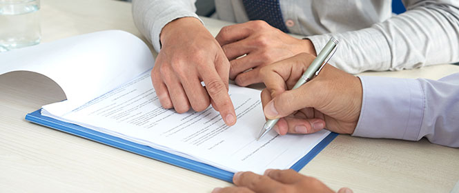 Como o LMI no seguro? Na imagem, corretor de seguros explica a dono de empresa como funciona o LMI no seguro