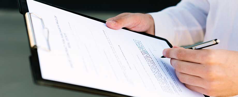 Qual o custo de contratar um seguro garantia? Na imagem, dono de grande empresa assinando contrato de seguro, que trará tranquilidade para realizar seus serviços