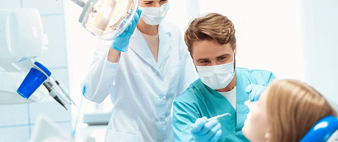 Quanto custa um seguro odontológico? Na imagem, mulher no dentista reforça a importância de um seguro odontológico para cuidados bucais