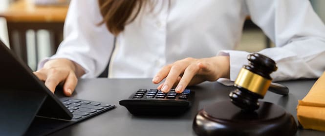 Como calcular o valor do seguro garantia para licitações? Na imagem, mulher calculando o valor de acordo com a proteção exigida no edital