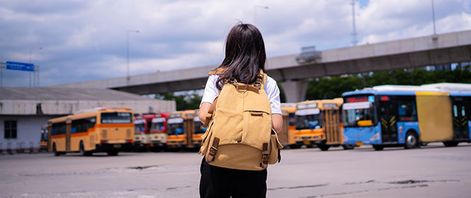 Qual o valor do seguro para ônibus? Na imagem, passageira em rodoviária que vai viajar em um veículo com cobertura de seguro RC ônibus