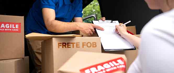 Frete Fob: Quando escolher esta modalidade de frete? Na imagem, vemos comprador assinando documentação após receber mercadoria