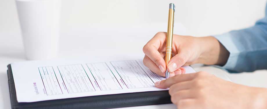 Quais são os seguros obrigatórios para empresas? Na imagem, microempreendedor assinando contrato de negociação após contratar seguro como garantia