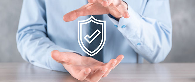 Quem pode contratar seguro compreensivo empresarial? Na imagem, dono de empresa segurando escudo, representando a proteção adquirida após contratação de seguro