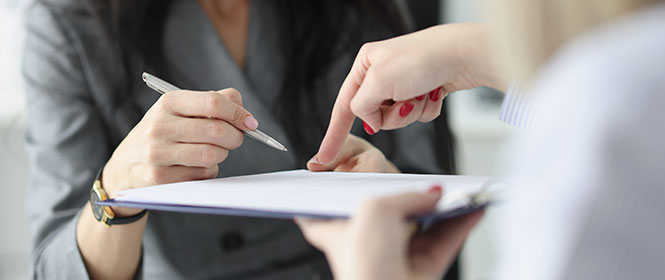 Como funciona o seguro garantia contratual para licitações? Na imagem, dona de empresa fecha contrato de seguro após ser contemplada em licitação pública