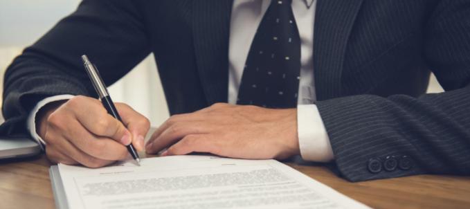 seguro-garantia-contratual-licitacao-como-funciona O que é seguro garantia contratual licitação? Na imagem, prestador de serviço assina contrato de licitação, evidenciando importância do seguro para garantir o cumprimento