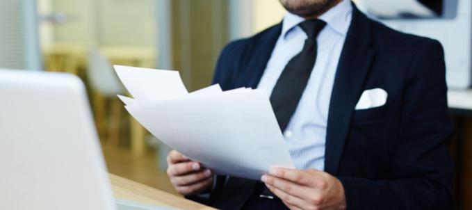o-que-e-seguro-quebra-de-garantia O que é seguro quebra de garantia? Na imagem, homem lendo documento sobre como funciona seguro quebra de garantia.