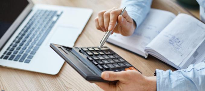 qual-o-valor-de-um-seguro-de-carga Qual o valor do seguro de carga? Na imagem, representando de uma transportadora calculando o preço do seguro de carga para contratar as melhores coberturas.