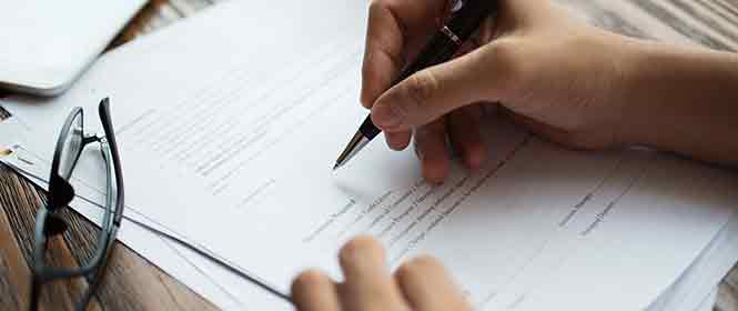 seguradora-de-garantia-e-corretora-de-seguros-entenda-a-diferença Seguradora de garantia e corretora de seguros: na imagem, corretor de seguros lendo contrato com atenção