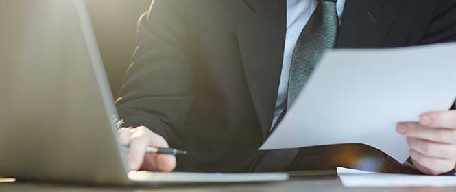 Seguro garantia contratual: como contratar? Na imagem, dono de empresa lendo como funciona a contratação do seguro garantia de contratos.